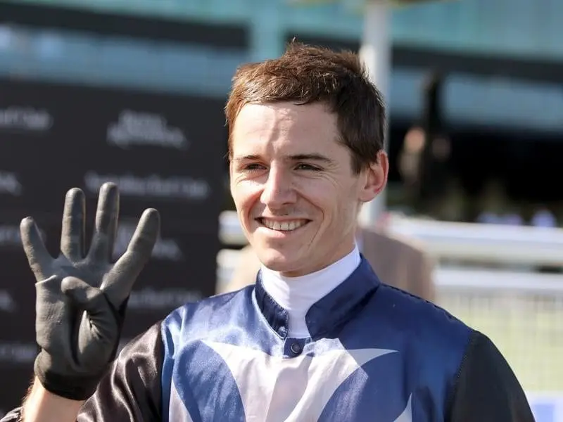 Jockey Jason Collett gestures after winning his 4th race