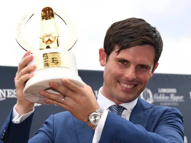 Trainer James Cummins lifts the Golden Slipper trophy