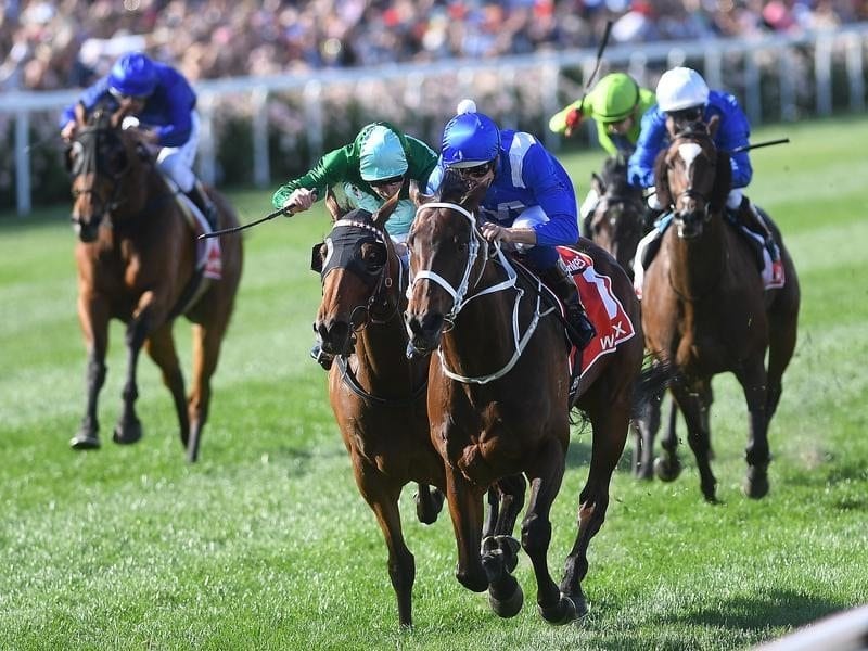 Hugh Bowman rides Winx (third from left) to victory in the Cox Plate.
